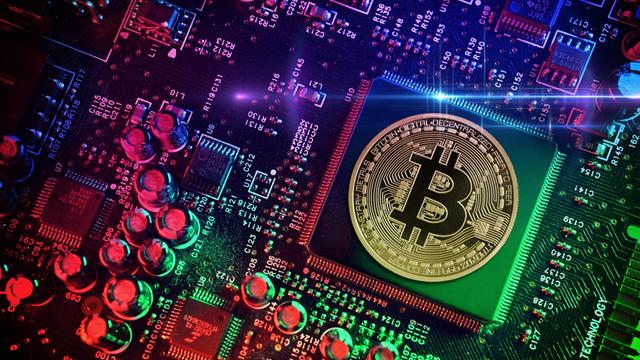 Computerchip mit Bitcoin-Münze, Symbolfoto 