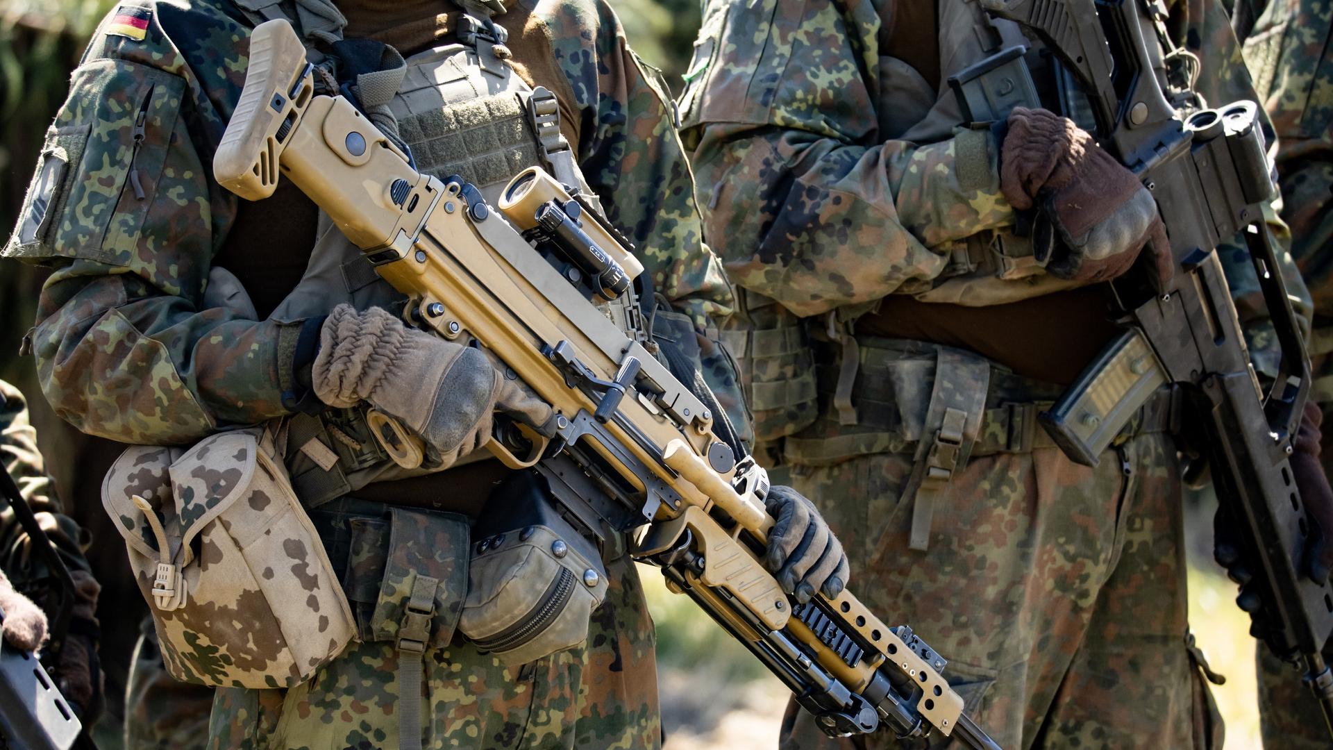 Zwei Bundeswehrsoldaten halten Maschinengewehre beim Tag der Bundeswehr in Neubrandenburg in den Händen