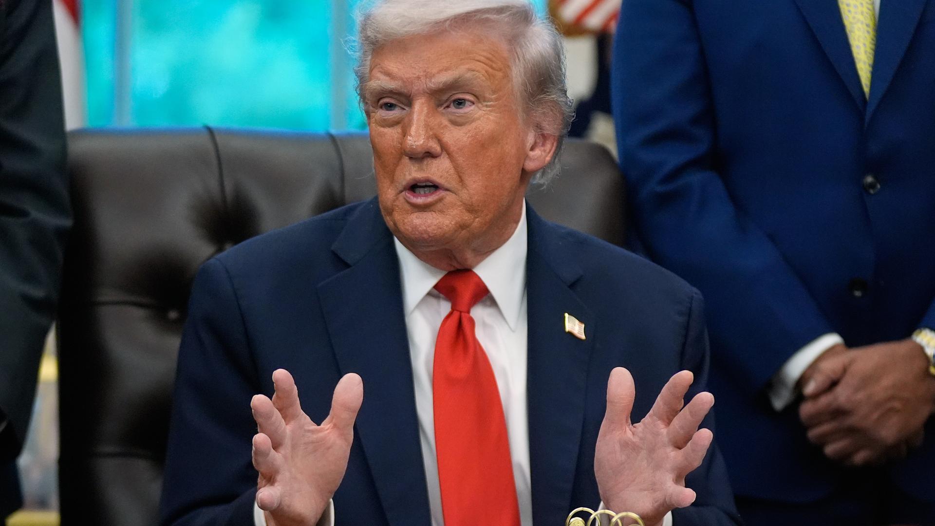 Donald Trump sitzt an seinem Schreibtisch im Oval Office und breitet die Hände aus. Donald Trump sitzt an seinem Schreibtisch im Oval Office und breitet die Hände aus.