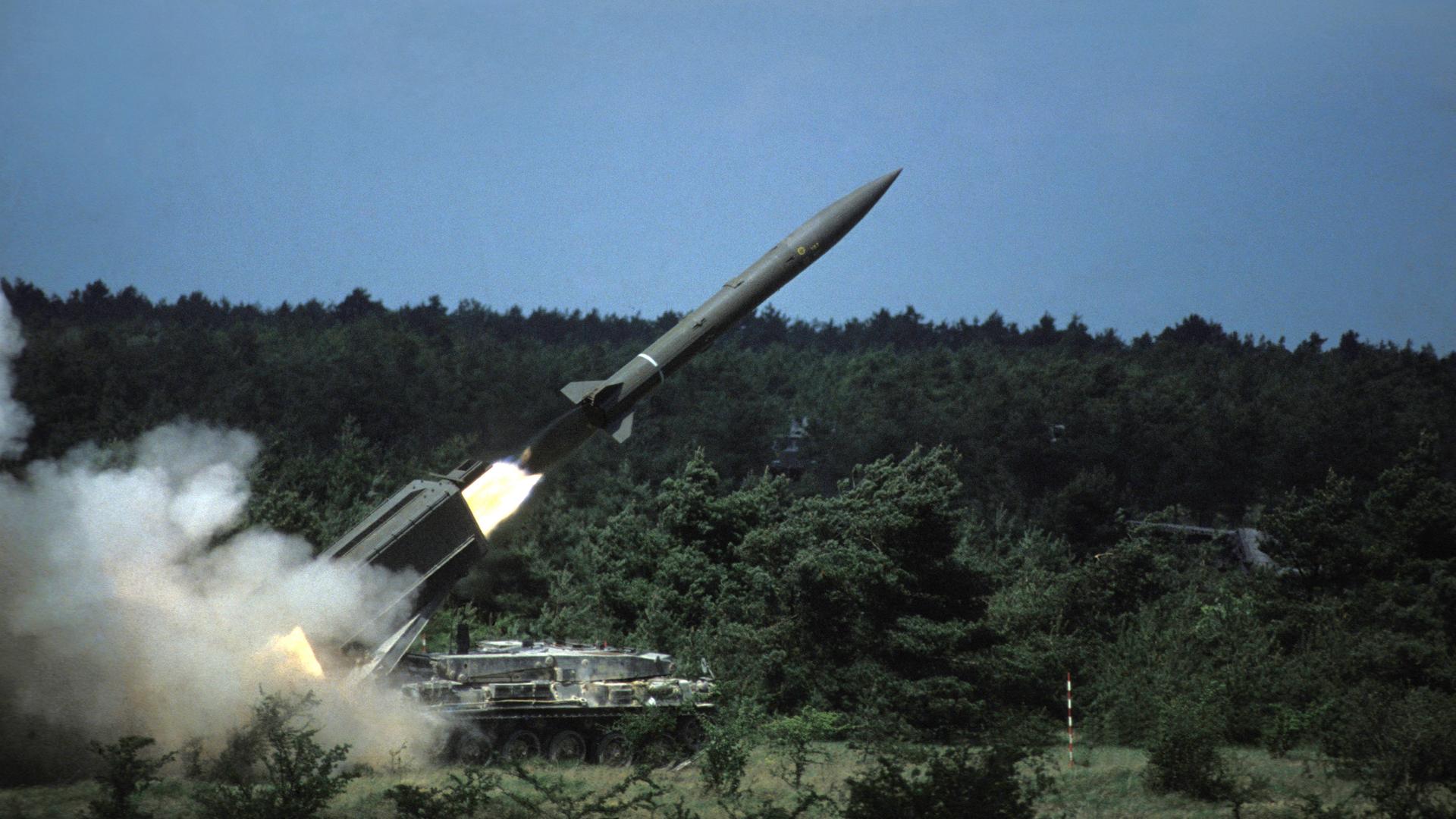 Aus einem großen Armeefahrzeug wird eine französische Atomrakete abgefeuert. Drum herum Büsche und grüne Natur. Aus einem großen Armeefahrzeug wird eine französische Atomrakete abgefeuert. Drum herum Büsche und grüne Natur.