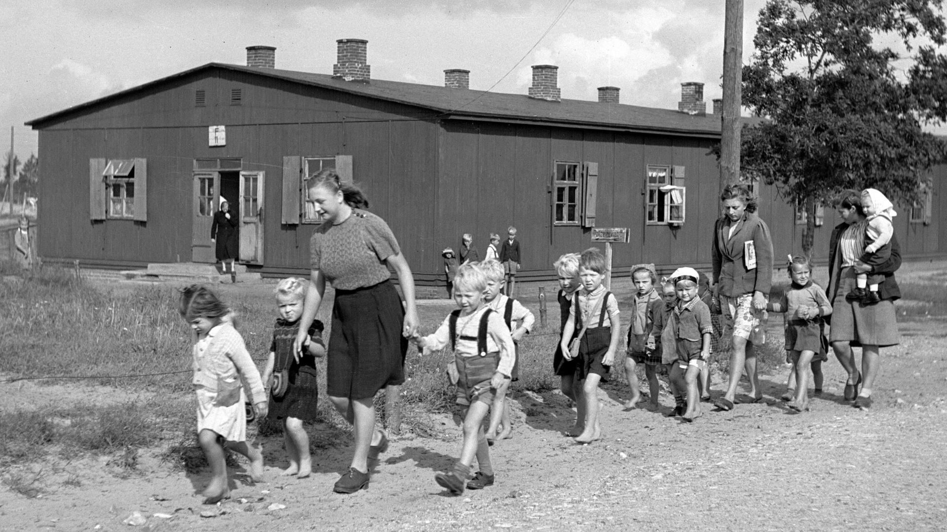 Historisches Foto einer Gruppe von Kindern mit Betreuerinnen in einem Lager für deutsche Flüchtlinge in Oxböl, Dänemark, 1948. Historisches Foto einer Gruppe von Kindern mit Betreuerinnen in einem Lager für deutsche Flüchtlinge in Oxböl, Dänemark, 1948.