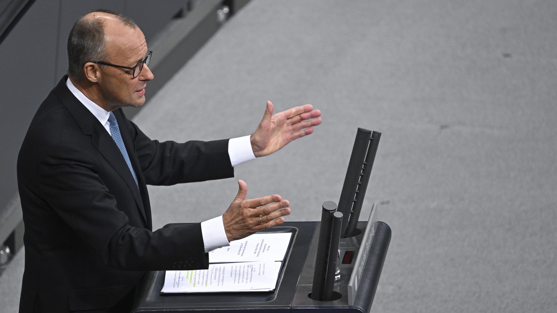 Bundeskanzler Friedrich Merz (CDU) steht mit offenen Händen am Rednerpult im Deutschen Bundestag Bundeskanzler Friedrich Merz (CDU) steht mit offenen Händen am Rednerpult im Deutschen Bundestag