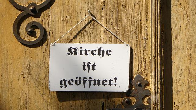 "Kirche ist geöffnet" steht auf dem Schild an einer Kirchentür "Kirche ist geöffnet" steht auf dem Schild an einer Kirchentür