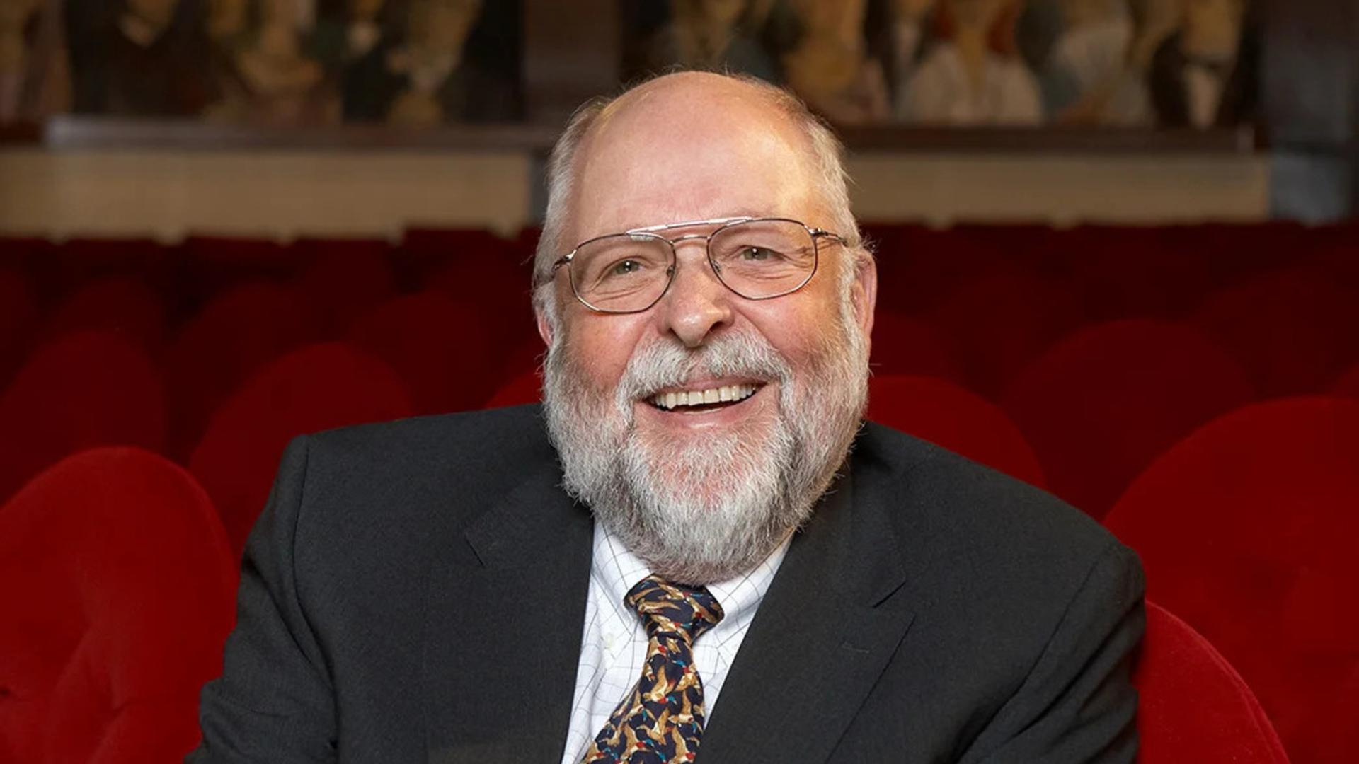 Klaus Tschira: Porträt als heiter lachender älterer Herr, mit Brille, Anzug, Krawatte und Vollbart
