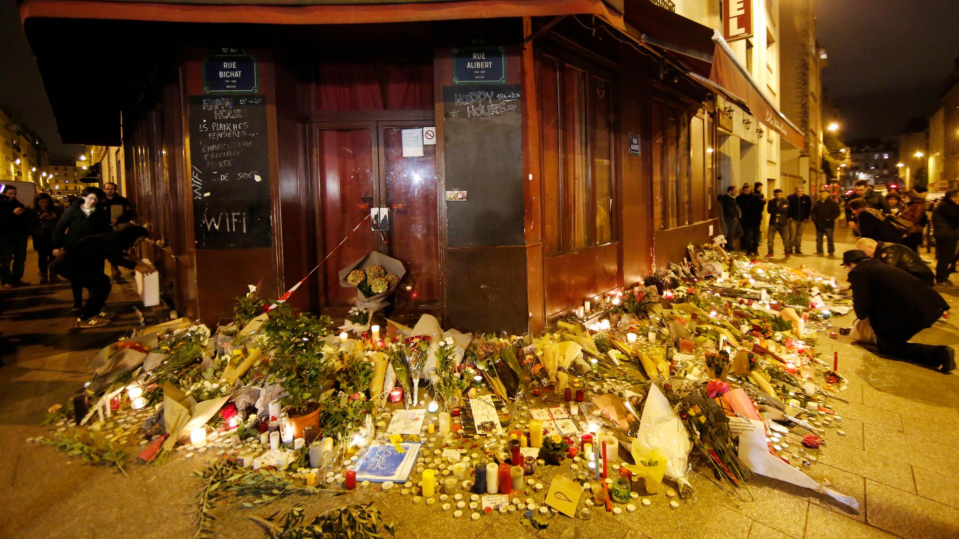 Brennende Kerzen und Blumen liegen am 14.11.2015 in der Rue Alibert in Paris vor der Bar "Le Carillion".