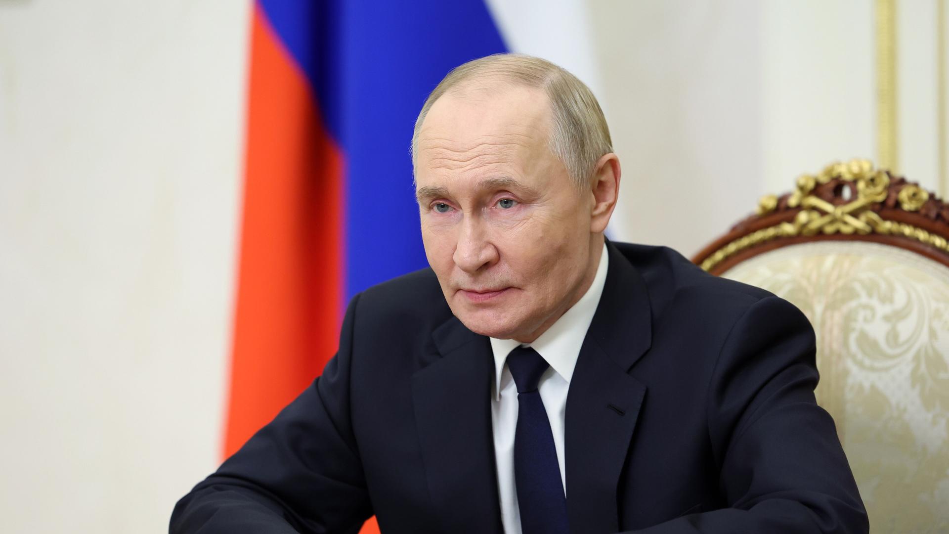 Der russische Präsident Wladimir Putin sitzt an einem Tisch und spricht in eine Kamera. Der russische Präsident Wladimir Putin sitzt an einem Tisch und spricht in eine Kamera.