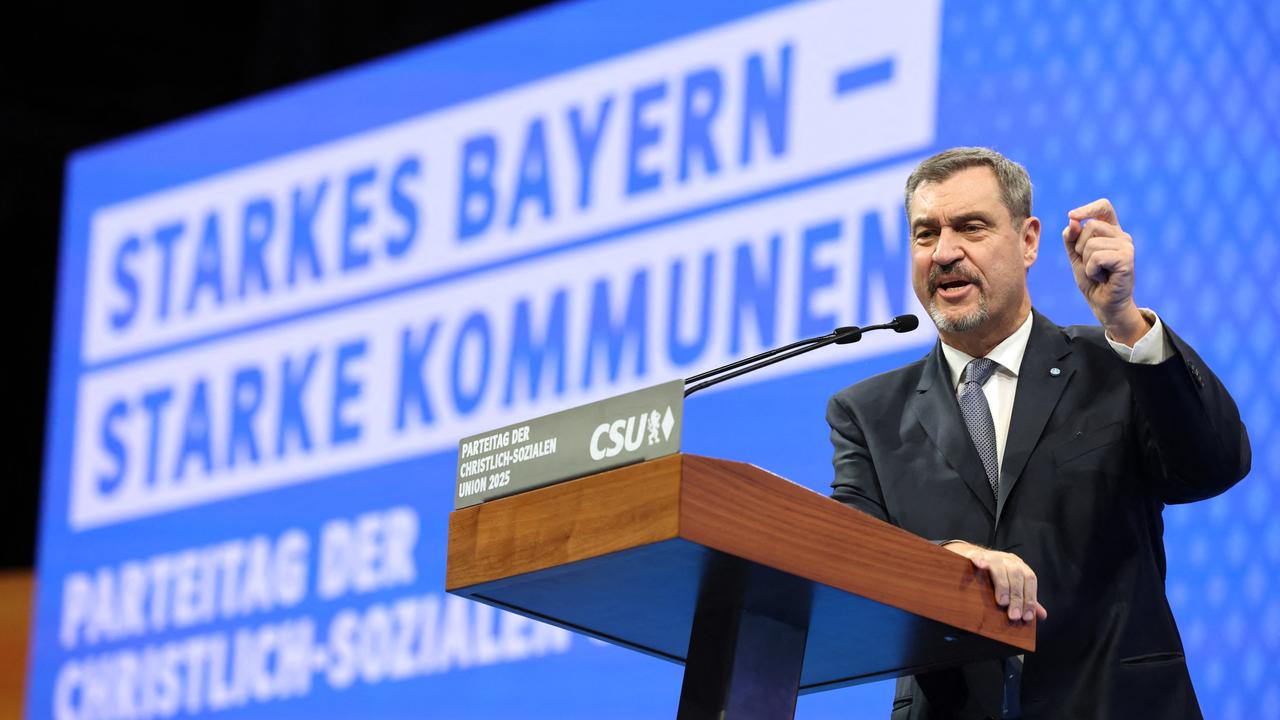 CSU-Chef Söder steht an einem Rednerpult und hebt die linke Hand, um seinen Worten Nachdruck zu verleihen. Im Hintergrund sieht man auf einer großen Tafel das Motto: Starkes Bayern - Starke Kommunen