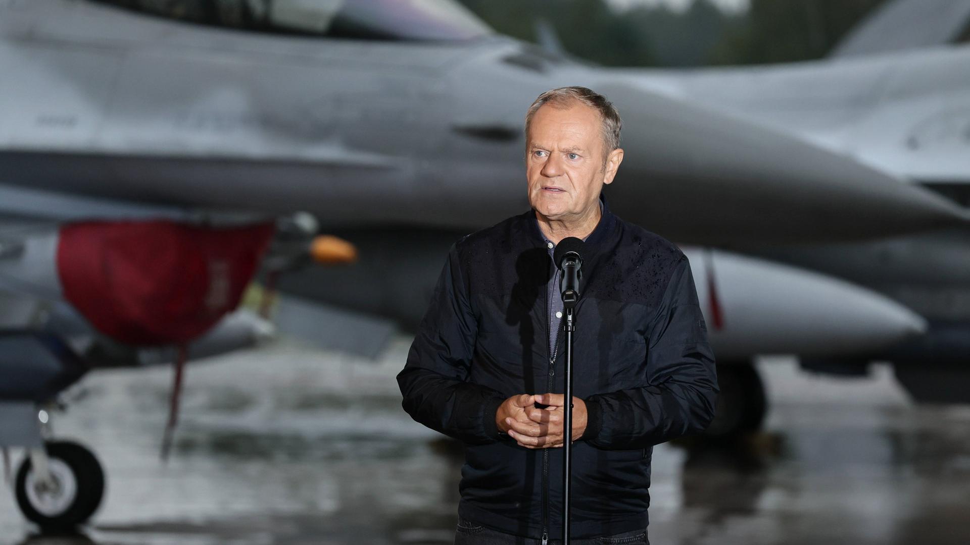 Donald Tusk spricht am 11.9.2025 bei einem Treffen mit polnischen F-16-Piloten, im Hintergrund ist ein Kampfjet zu sehen. Donald Tusk spricht am 11.9.2025 bei einem Treffen mit polnischen F-16-Piloten, im Hintergrund ist ein Kampfjet zu sehen.