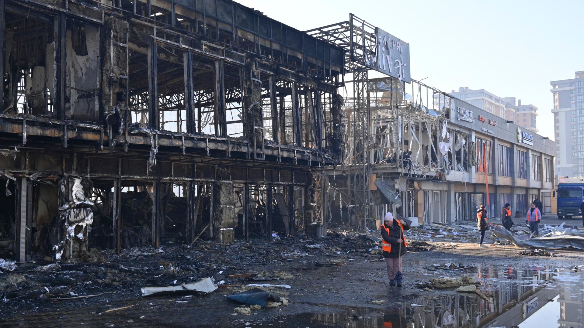 Odessa: Städtische Arbeiter räumen auf, nachdem russische Drohnen während des nächtlichen Angriffs Geschäfte getroffen haben. 