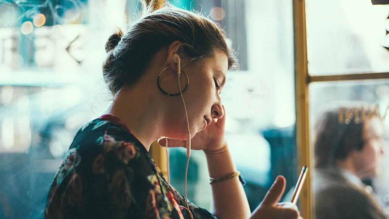 Eine junge Frau mit In-Ear-Kopfhörern