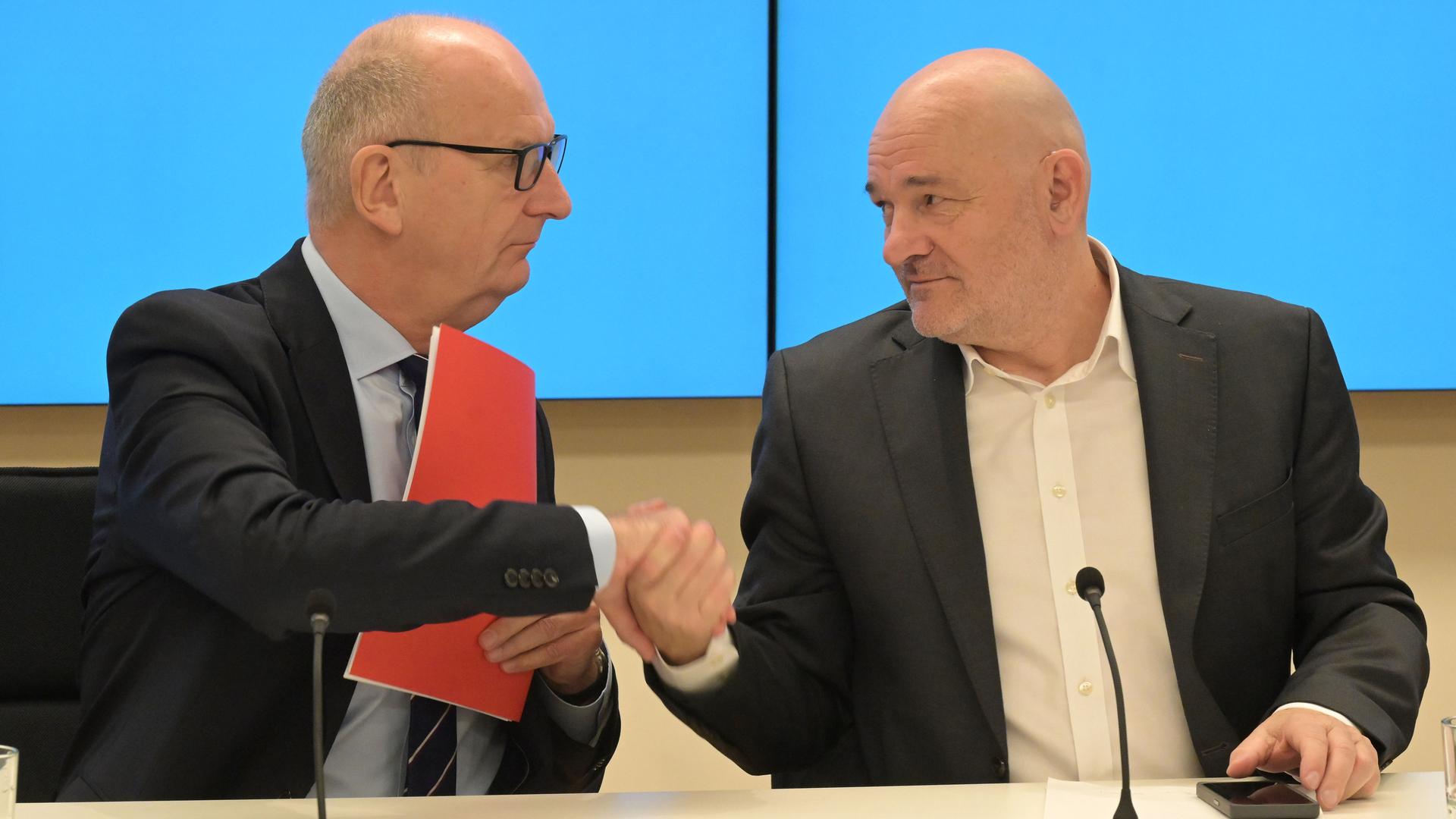 Dietmar Woidke schüttelt Robert Crumbach bei der Landespressekonferenz im Brandenburger Landtagsgebäude die Hand.